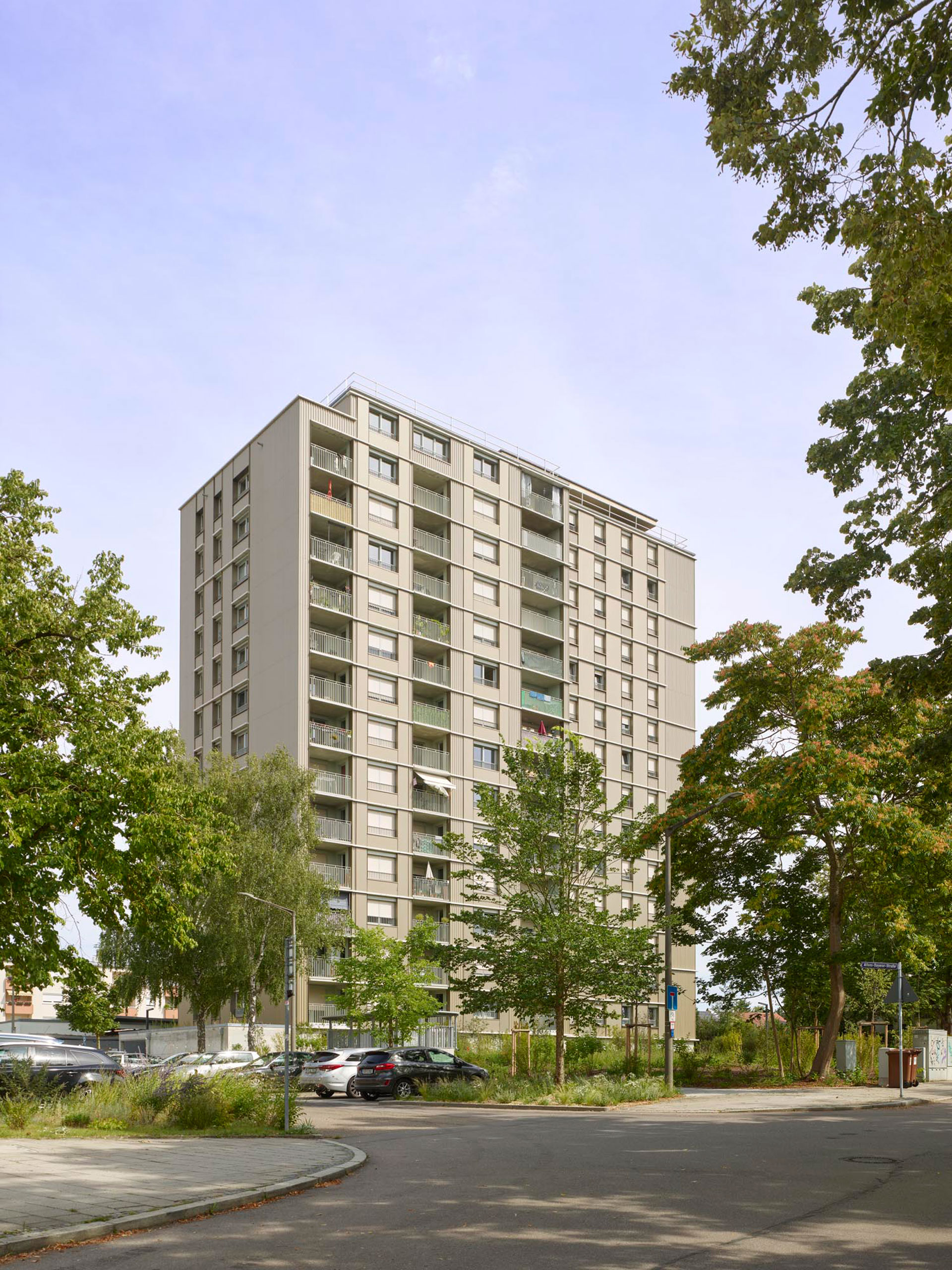 Außenansicht des Holzhochhauses mit Parkplatz
