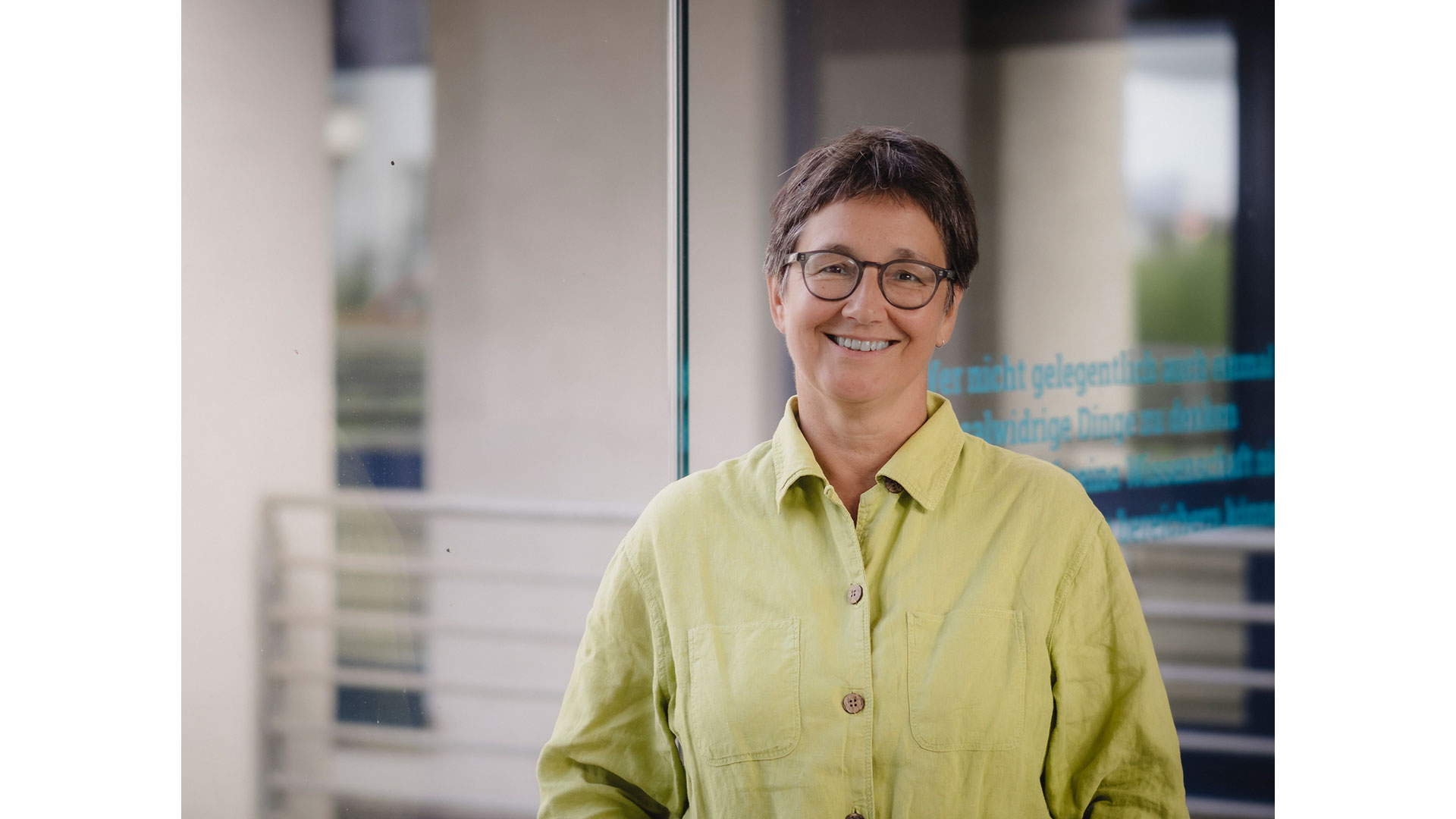 Portrait von Dr. Stephanie Bock mit Brille und grünem Shirt.