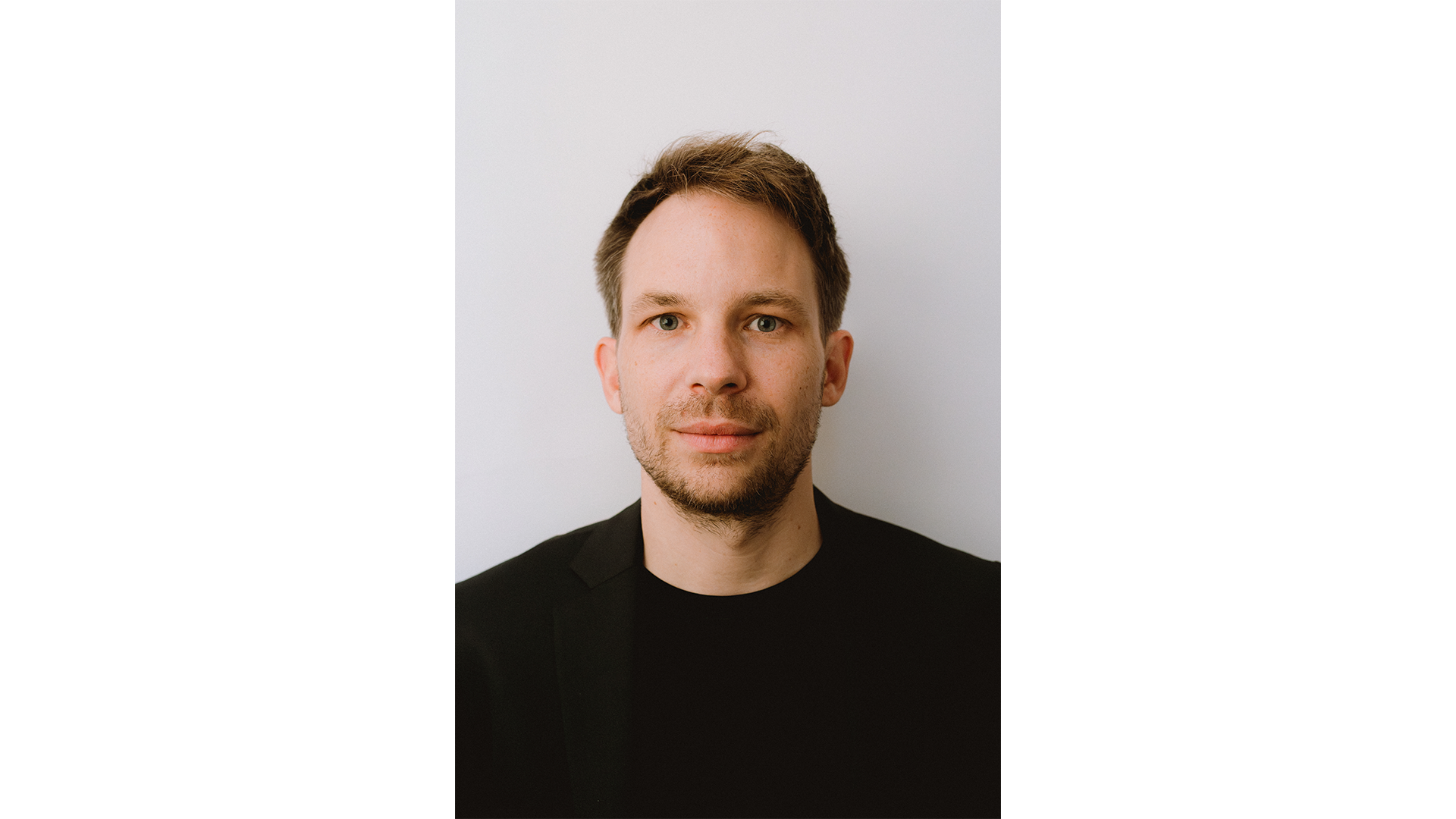 Portrait im Hochkantformat von Prof. Florian Kaiser in schwarzem Oberteil.