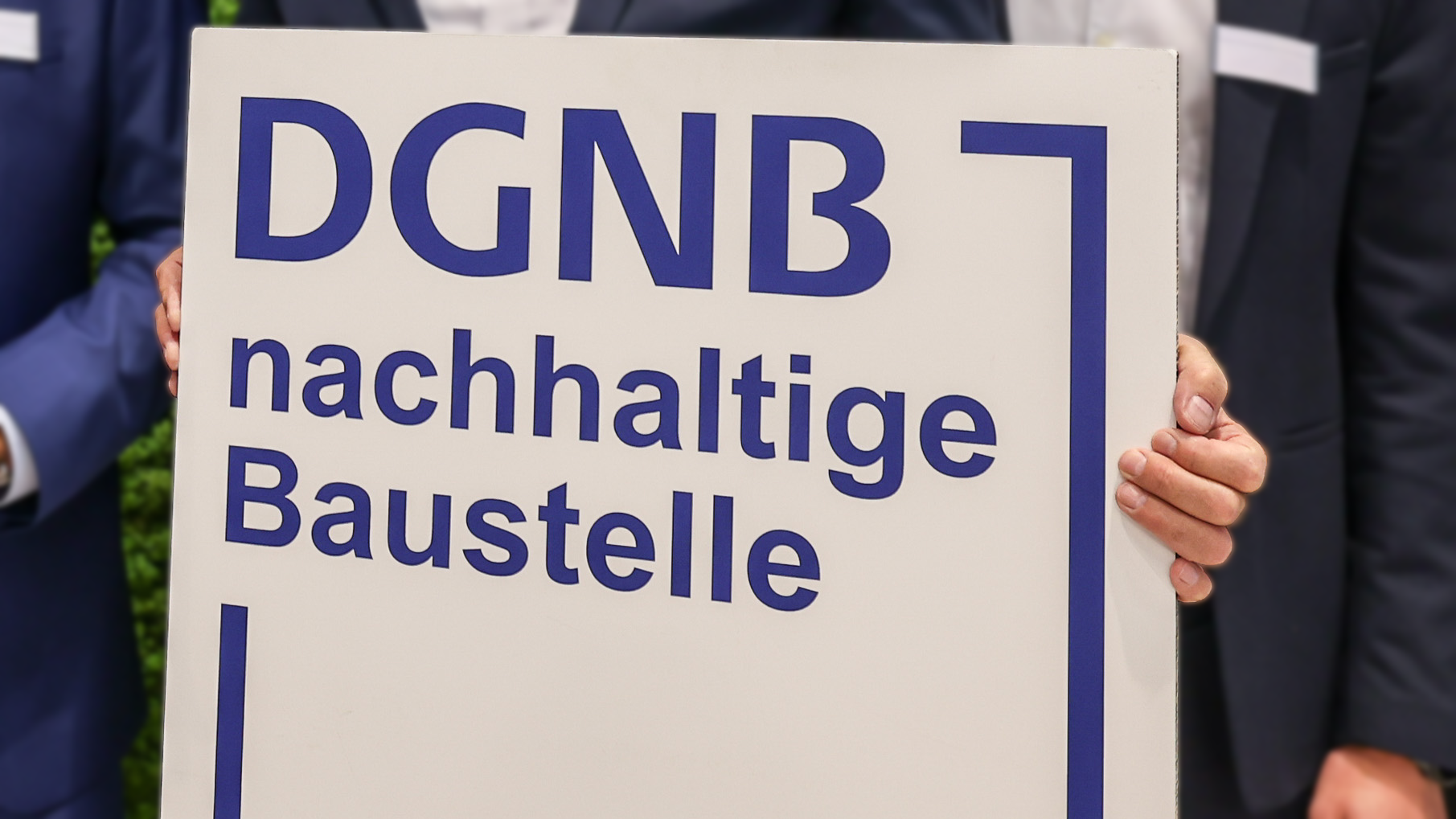 Personen mit DGNB Wavequad aus Pappe mit der Aufschrift "DGNB nachhaltige Baustelle"