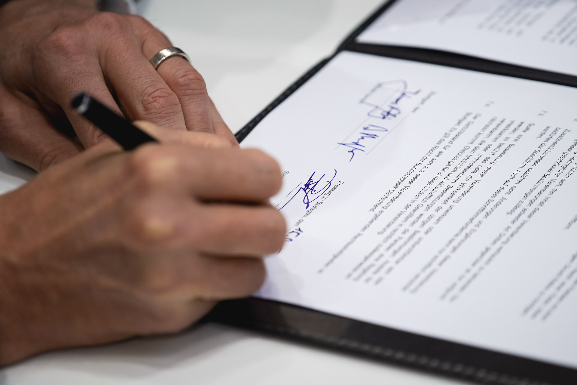 Unterschrift eines Vertrages auf der BAU 2019