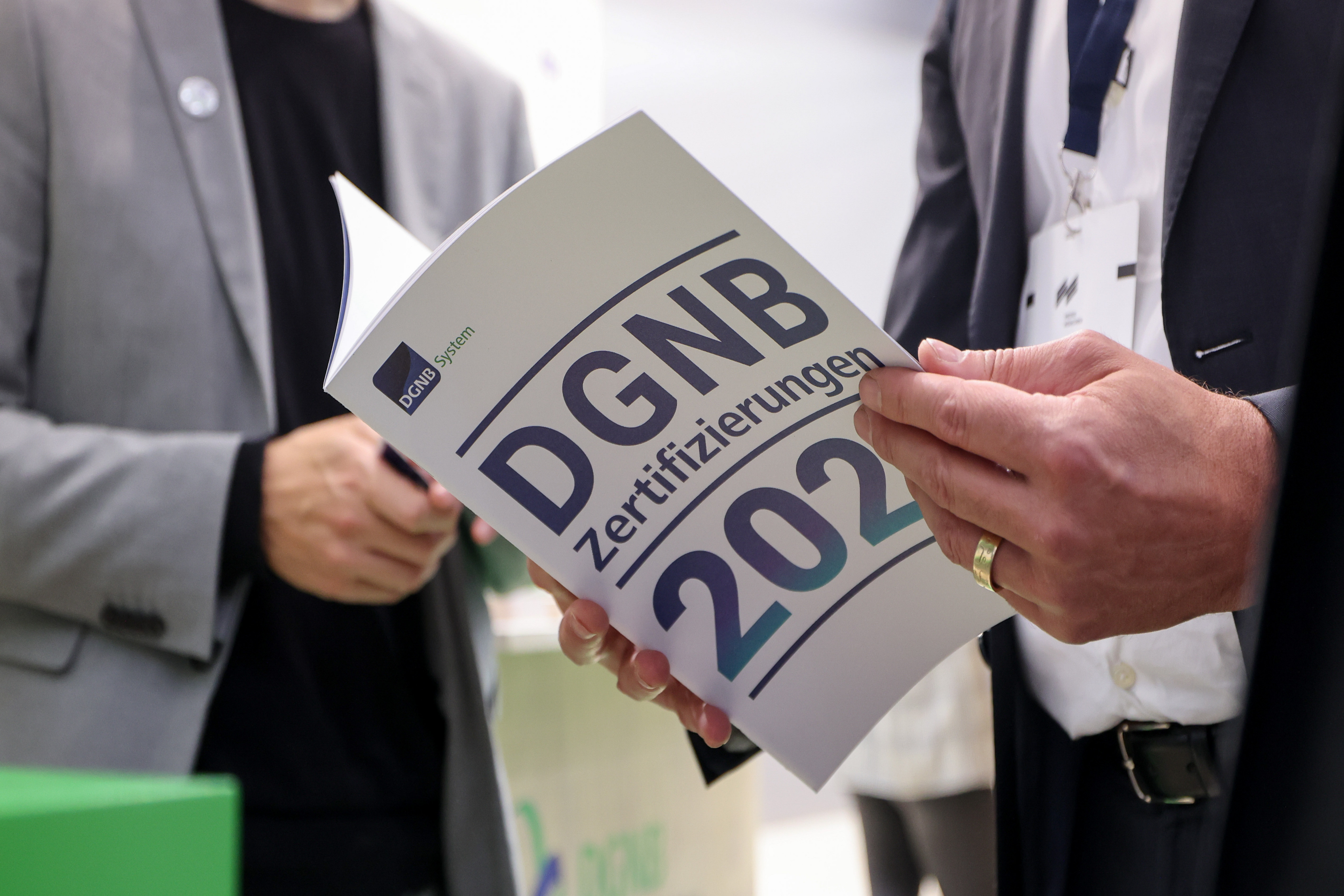 DGNB Zertifizierungsreport wird in den Händen gehalten und durchgeblättert.