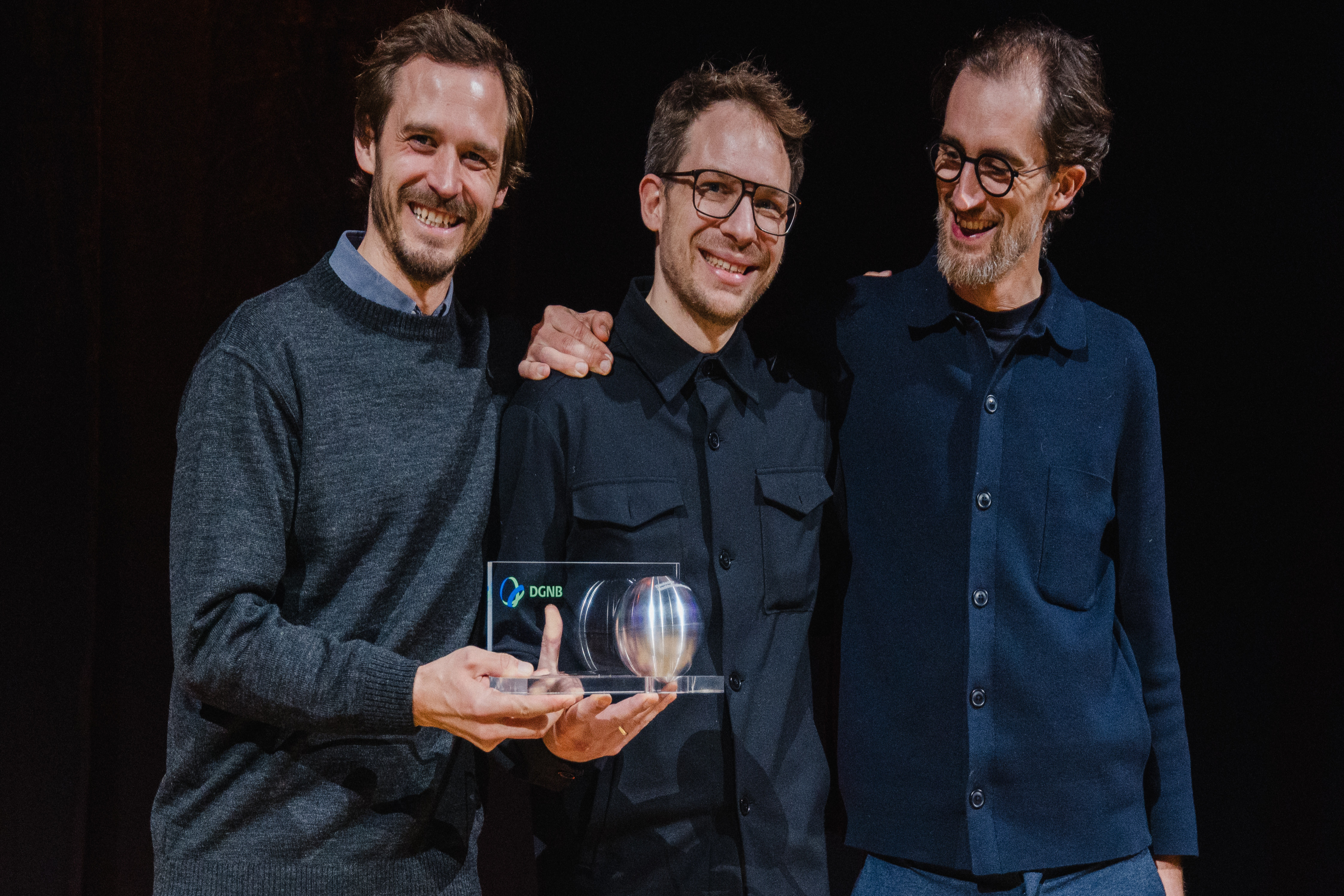 Die Gewinner des 13. Deutschen Nachhaltigkeitspreises Architektur halten die Preiskugelfest.