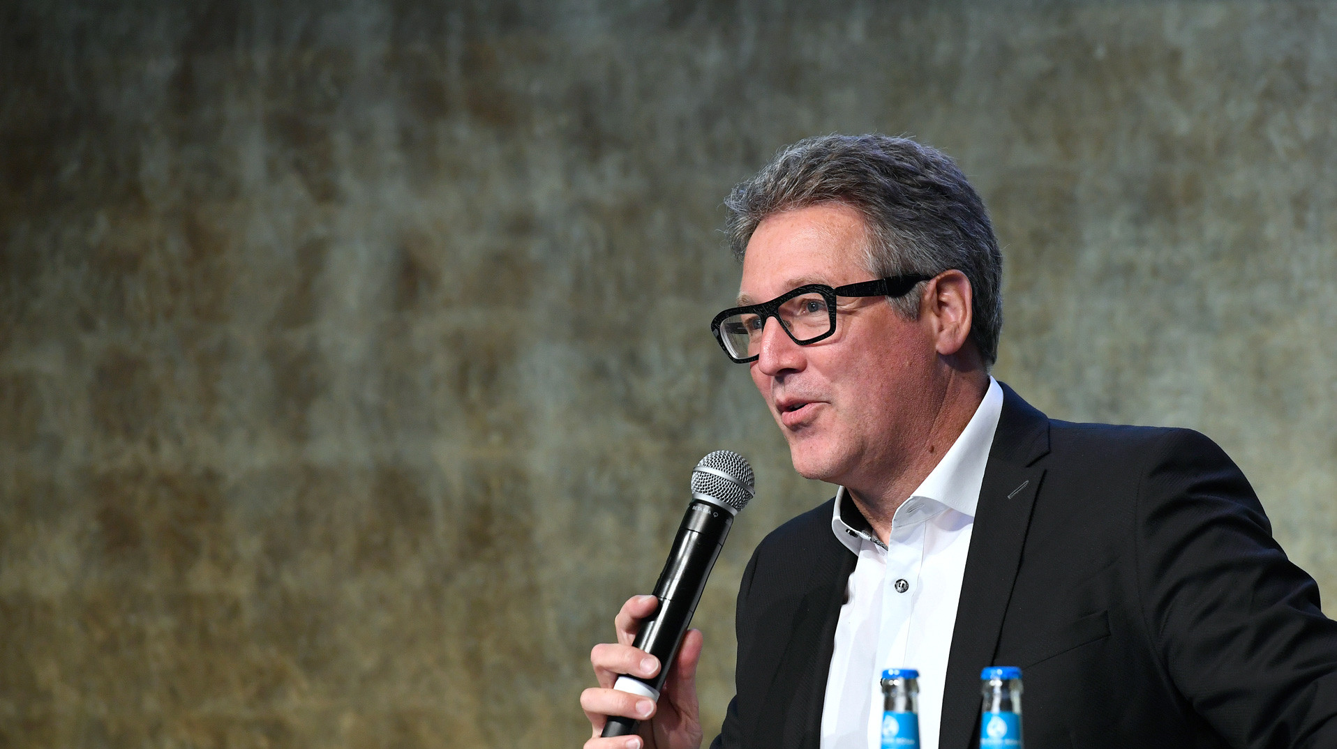 Johannes Kreißig als Referent auf dem Podium mit Mikrofon beim DGNB Tag der Nachhaltigkeit 2022